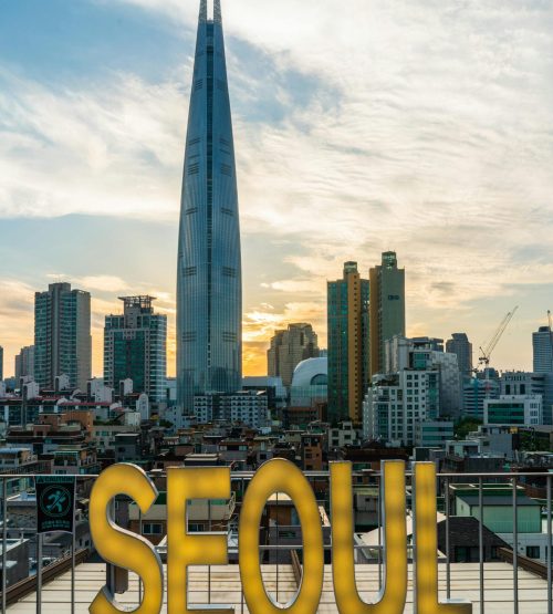 Stunning view of Lotte Tower and Seoul's skyline during sunset, highlighting the city's urban architecture.